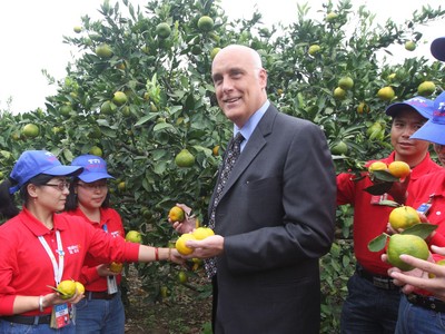 沃爾瑪中國公司事務(wù)高級副總裁博睿（中）考察大理項目基地，并同沃爾瑪員工志愿者一起幫助受助農(nóng)戶收獲成熟的柑橘。